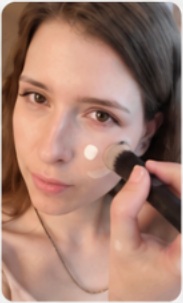 Woman applying makeup with a brush